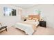 Bright bedroom with a rattan headboard bed, neutral-toned bedding, and natural light from two windows at 6087 S Elizabeth Way, Centennial, CO 80121