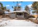 Stylish single-story home with a modern gray brick facade and covered porch, surrounded by a snowy landscape at 6087 S Elizabeth Way, Centennial, CO 80121