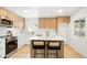 Bright kitchen featuring wooden cabinets, stainless steel appliances, a center island with seating, and white countertops at 6087 S Elizabeth Way, Centennial, CO 80121