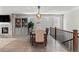 Open dining room with modern chandelier, next to living room with fireplace and cabinets at 27234 E Quarto Ave, Aurora, CO 80016