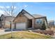 Desirable exterior showcases stonework, a two-car garage, and a beautiful lawn with mature landscaping at 27234 E Quarto Ave, Aurora, CO 80016