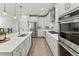 Modern kitchen features stainless steel appliances, white cabinetry, and marble countertops at 27234 E Quarto Ave, Aurora, CO 80016