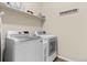 Functional laundry room equipped with modern washer and dryer, plus storage shelving at 27234 E Quarto Ave, Aurora, CO 80016