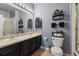 Bathroom featuring a double sink vanity, ample lighting, and decorative shelving at 18989 E Warren Dr # G303, Aurora, CO 80013