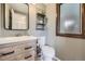 Charming half bathroom with wood-look vanity, decorative shelves and a window at 10397 Yates Ct, Westminster, CO 80031