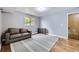 Comfortable bonus room with hardwood floors, a gray couch and a bright window at 10397 Yates Ct, Westminster, CO 80031