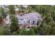 High aerial view of a large home showcasing its deck, landscaping, and mature trees at 22554 Treetop Ln, Golden, CO 80401