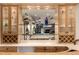 Elegant bar area with glass shelves displaying an assortment of liquors and glassware at 22554 Treetop Ln, Golden, CO 80401