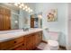 Bright bathroom featuring wood cabinets, white tile, and a glass-enclosed shower at 22554 Treetop Ln, Golden, CO 80401