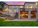 Beautiful backyard, with lush lawn, featuring a deck and a covered patio area with stone flooring at 22554 Treetop Ln, Golden, CO 80401
