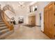 Grand foyer with a curved staircase, chandelier, double doors, and neutral tile flooring at 22554 Treetop Ln, Golden, CO 80401