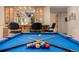 Game room with a full-size pool table, cue sticks, and a bar area in the background at 22554 Treetop Ln, Golden, CO 80401