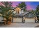 Exterior shot of a two-car garage with stone accents and an upper level balcony at dusk at 22554 Treetop Ln, Golden, CO 80401