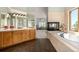 Spacious main bathroom with dual vanities, soaking tub, and views of the outdoors at 22554 Treetop Ln, Golden, CO 80401