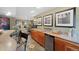 Wet bar area adjacent to exercise room, with sink, mini fridge, and artful decor at 15 Amaranth Dr, Littleton, CO 80127