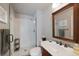 Cozy bathroom featuring a glass shower, white subway tiles, and a wood-trimmed mirror at 15 Amaranth Dr, Littleton, CO 80127