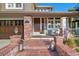 Inviting front porch with brick steps and pillars, plus space for seating at 15 Amaranth Dr, Littleton, CO 80127