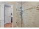 Shower featuring glass doors and tiled surround, coupled with view to the bathroom vanity at 15 Amaranth Dr, Littleton, CO 80127