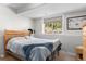 Bright bedroom with wood-framed bed, neutral carpet, and a large window offering backyard views at 400 Upper Forest Rd, Idaho Springs, CO 80452