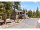 Two-story exterior featuring a stone chimney, and private drive surrounded by tall trees at 400 Upper Forest Rd, Idaho Springs, CO 80452