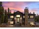 Charming gray exterior home featuring a stone chimney and inviting front porch at dusk at 400 Upper Forest Rd, Idaho Springs, CO 80452