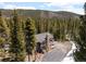 Aerial view of a house surrounded by dense woods and mountain backdrop at 400 Upper Forest Rd, Idaho Springs, CO 80452