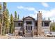 Charming gray exterior home featuring a stone chimney and inviting front porch at 400 Upper Forest Rd, Idaho Springs, CO 80452