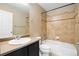 Cozy full bathroom featuring tile flooring, dark cabinets, and a shower/tub combination at 4732 S Coolidge St, Aurora, CO 80016