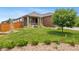 Well-manicured front yard and brick home with covered porch at 4732 S Coolidge St, Aurora, CO 80016