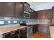 Close-up of kitchen with stainless steel appliances, wood cabinets, tile backsplash and granite countertops at 4732 S Coolidge St, Aurora, CO 80016