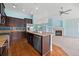 Spacious kitchen features dark wood cabinetry, stainless steel appliances, granite counters, and an island with sink at 4732 S Coolidge St, Aurora, CO 80016