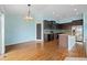 Modern kitchen with dark cabinetry, stainless appliances, a center island and hardwood floors at 4732 S Coolidge St, Aurora, CO 80016