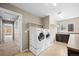 Well-lit laundry room features a washer, dryer, sink and storage at 4732 S Coolidge St, Aurora, CO 80016