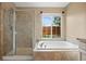 Updated main bathroom with large tub, tiled shower, and a window offering natural light at 4732 S Coolidge St, Aurora, CO 80016