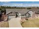 Stunning aerial view of a home showcasing its expansive driveway, two-car garage, and beautifully landscaped surroundings at 15137 W 50Th Pl, Golden, CO 80403