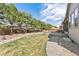Well-manicured backyard features a lush lawn, mature trees, and a stone pathway leading to a patio area at 15137 W 50Th Pl, Golden, CO 80403