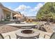 Outdoor space featuring a fire pit, patio with seating, and lush lawn surrounded by mature trees at 15137 W 50Th Pl, Golden, CO 80403