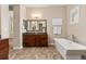 A relaxing bathroom features wood cabinets, tile floor and a soaking tub at 15137 W 50Th Pl, Golden, CO 80403