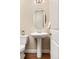 Elegant powder room with a pedestal sink, decorative mirror, and neutral color palette, creating a clean and inviting space at 15137 W 50Th Pl, Golden, CO 80403