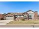 Charming single Gathering home featuring a stone facade, manicured lawn and a two-car garage, with a blue sky above at 15137 W 50Th Pl, Golden, CO 80403