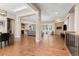 Open concept living room with hardwood floors, modern lighting, a brick fireplace and an adjacent dining and kitchen area at 15137 W 50Th Pl, Golden, CO 80403