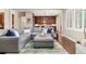Open-concept living room with a large sectional, stylish rug, and hardwood floors leading into an updated kitchen at 15137 W 50Th Pl, Golden, CO 80403