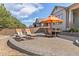 Stone patio with outdoor seating, lounge chairs, and a large umbrella, perfect for entertaining guests at 15137 W 50Th Pl, Golden, CO 80403