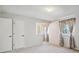 Bedroom with neutral walls and carpet features closets and bright windows with colorful curtains at 19322 E Eldorado Dr, Aurora, CO 80013