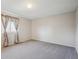 Bright and airy bedroom features neutral carpet, walls, and a large window with colorful curtains at 19322 E Eldorado Dr, Aurora, CO 80013
