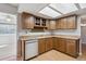 Well-lit kitchen features wood cabinetry, stone countertops, stainless steel dishwasher and wood laminate flooring at 19322 E Eldorado Dr, Aurora, CO 80013
