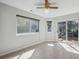 Bright living room with large windows, sliding glass door to deck, neutral paint, and modern ceiling fan at 19322 E Eldorado Dr, Aurora, CO 80013
