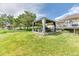 Expansive backyard featuring lush green grass, mature trees, a pergola, and a chicken coop at 2464 Remington Rd, Elizabeth, CO 80107