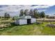 Spacious barn with white siding and green trim, featuring an open doorway and fenced pasture land at 2464 Remington Rd, Elizabeth, CO 80107
