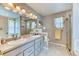 Well-lit bathroom featuring double sinks, granite countertops, tiled floors, large mirror, and a glass door shower at 2464 Remington Rd, Elizabeth, CO 80107